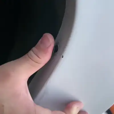 El forro del guardafango de un carro suelto, sin su grapa